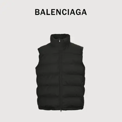 Balenciaga/巴黎世家 25Fw 后领圆环小标棉服马甲 定制开发高支高密梭织面料,是其高级质感的基石,高支数意味着纱线极细,从而织出纹理细腻、触感丝滑的表面;高密度则赋予了面料出色的挺括度、耐磨性与抗风能力.它避免了普通棉帆布的粗糙感,呈现出一种低调而精准的微光泽,为后续的刺绣与包边工艺提供了完美且稳定的基础.填充物选用珍珠棉,这是一种中空三维卷曲纤维,相比传统絮片,珍珠棉能提供更持久、均匀的蓬松感与回弹性,确保马甲轮廓饱满不塌陷,轻盈保暖的中空结构锁住空气,实现最佳保暖重量比,达成“轻盈如羽,温暖如裘”的穿着体验,填充工艺需确保棉体在绗缝格内均匀分布,无空洞或结块,这要求极高的充绒精度.所有裁片边缘均采用斜裁包边条进行全方位包裹.后领的标识刺绣采用数万针的高密度刺绣,图案饱满立体,边缘清晰锐利.底层面料稳定处理:在如此轻薄高密的面料上进行密集刺绣,极易导致面料收缩变形.品牌会在刺绣底层使用特制水溶衬或热熔衬,刺绣完成后这些衬布会消失,从而确保图案平整挺括,且不破坏面料本身的柔韧度.这是对手工与科技结合的极致考验,定制辅料三标,男女同款